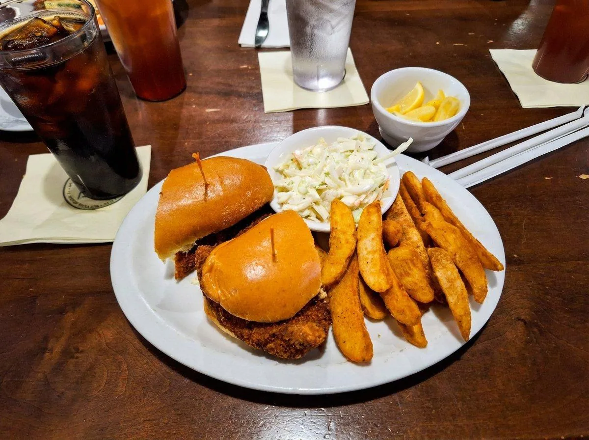 North Beach Fish Camp fried fish sandwich on brioche bun with waffle fries, coleslaw and lemon wedges, Neptune Beach