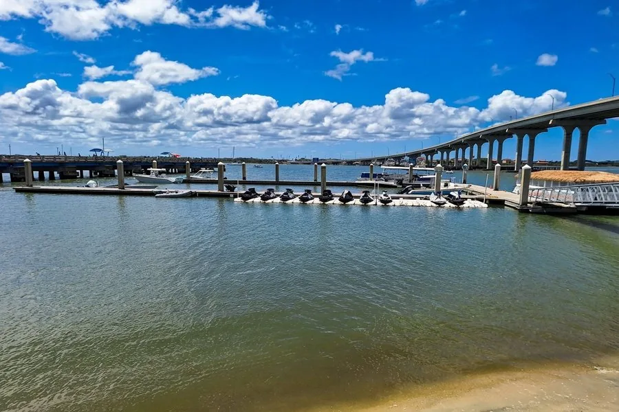Tolomato River waterfront view from Beaches at Vilano — boats and jet skis docked, Vilano Bridge in background