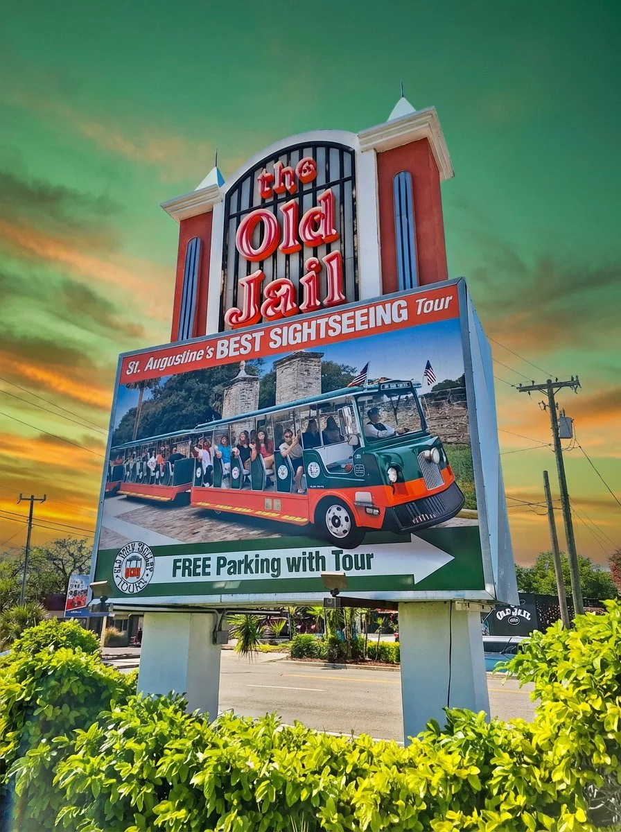The Old Jail sign in St. Augustine advertising trolley tours and free parking